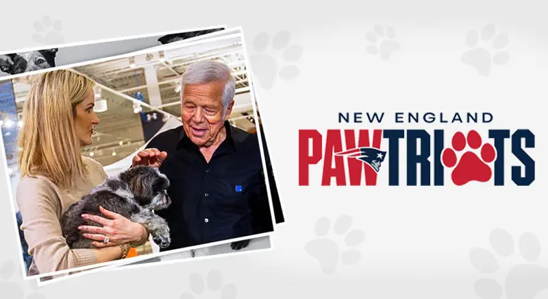 Two people smiling while holding a small dog, next to a “New England Pawtriots” logo with a red paw print replacing the “A.”