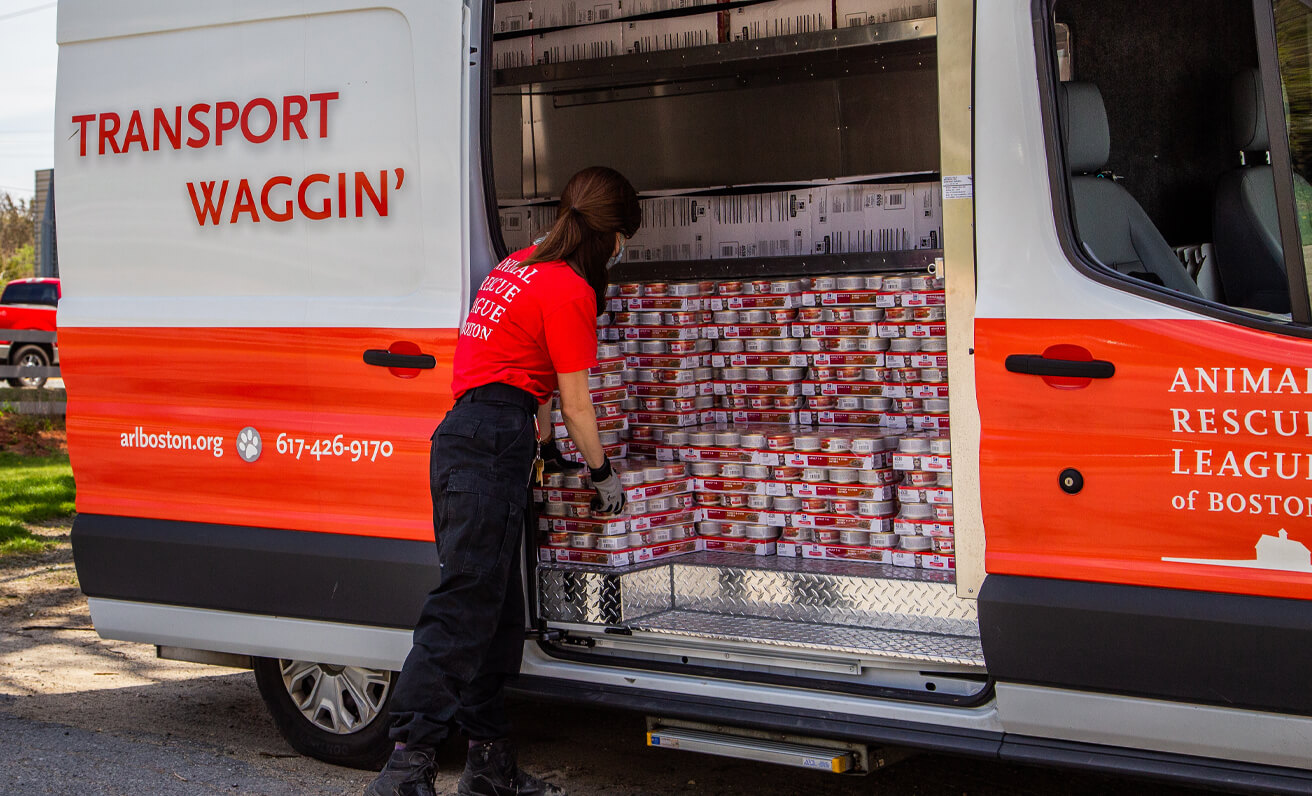 ARL staff member loading pet food onto ARL Transport Waggin' 