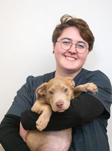 Aidan holding a small tan puppy