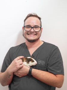 Ryan holding a tan and white guinea pig.