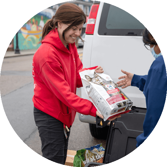 ARL staff member handing a bag of pet food to a person