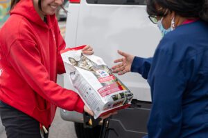 ARL staff member handing someone a bag of pet food