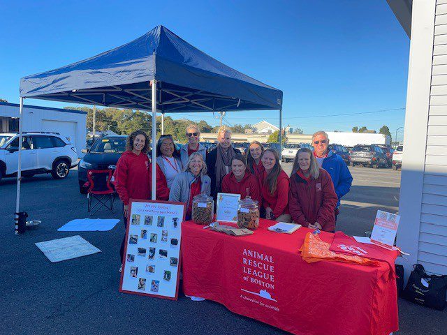 ARL staff posing outside next to a table with ARL materials